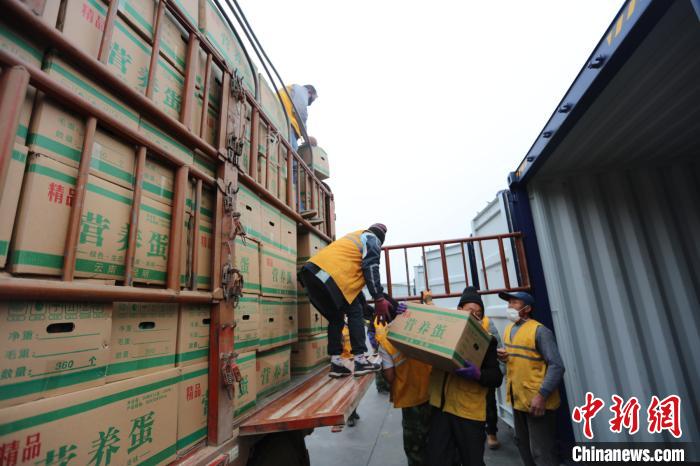 圖為鐵路裝卸作業(yè)人員正在將云南特色農(nóng)產(chǎn)品裝入集裝箱?！詈?攝