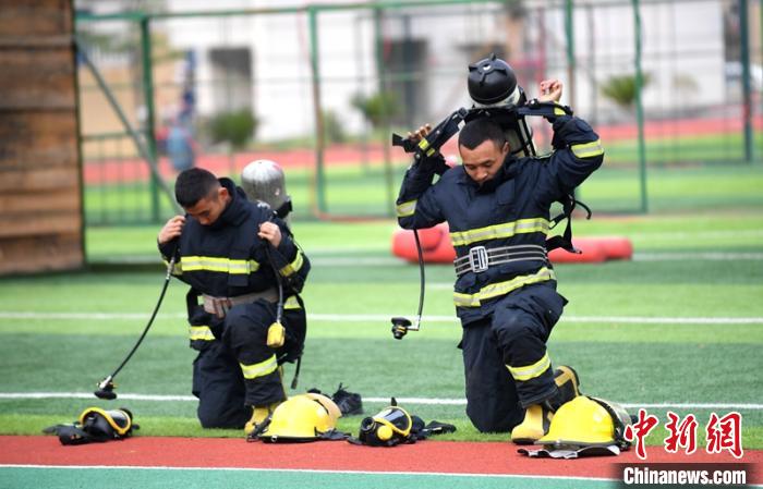 新消防員進(jìn)行穿戴空呼器展示?！⒅铱?攝