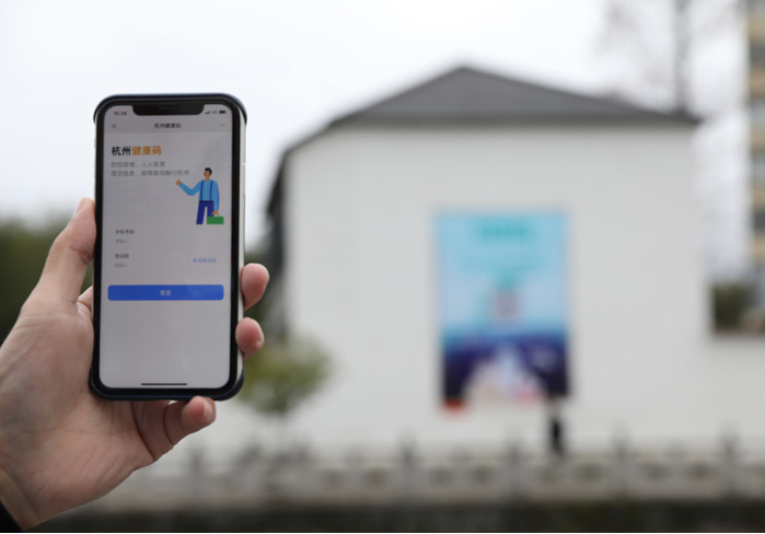 在浙江省杭州市臨安區(qū)天目山鎮(zhèn)，一名居民在“杭州健康碼”海報(bào)上掃碼申領(lǐng)個人二維碼。新華社發(fā)
