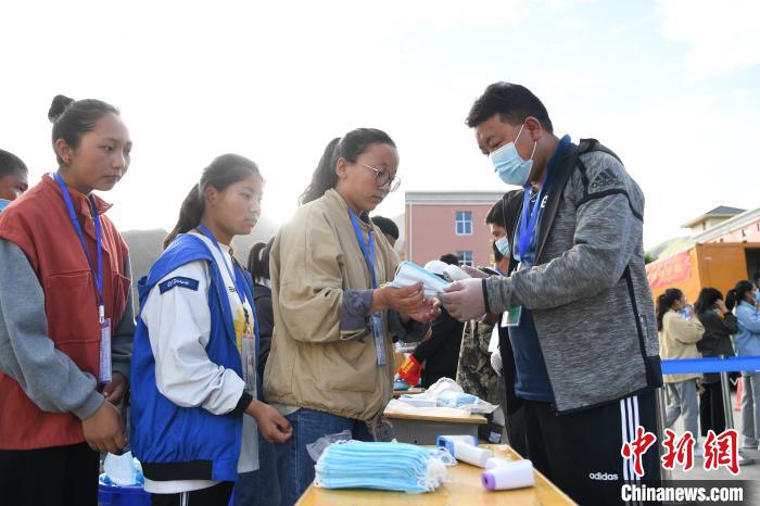 7月7日，考生在拉薩三高考點(diǎn)外領(lǐng)取口罩。　何蓬磊 攝