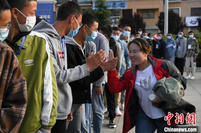 7月7日，拉薩三高考點(diǎn)外，領(lǐng)隊(duì)老師與考生擊掌鼓勁加油。　何蓬磊 攝