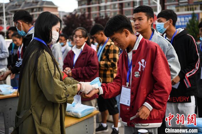 7月7日，考生在拉薩三高考點(diǎn)外測(cè)量體溫?！『闻罾?攝