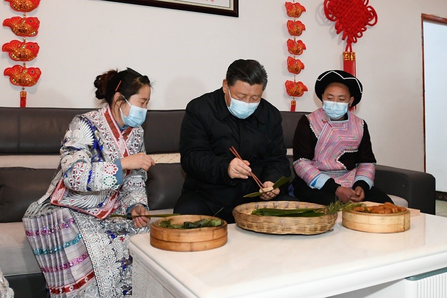 2021年2月3日下午，習(xí)近平在貴州畢節(jié)市黔西縣新仁苗族鄉(xiāng)化屋村苗族村民趙玉學(xué)家，同一家人邊聊家常邊制作當(dāng)?shù)貍鹘y(tǒng)節(jié)日食品黃粑。新華社記者 李學(xué)仁 攝